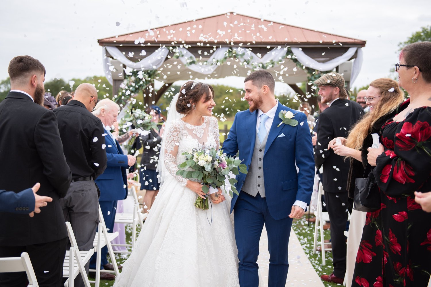 Tom and Bernadette smiling at each other as confetti falls
